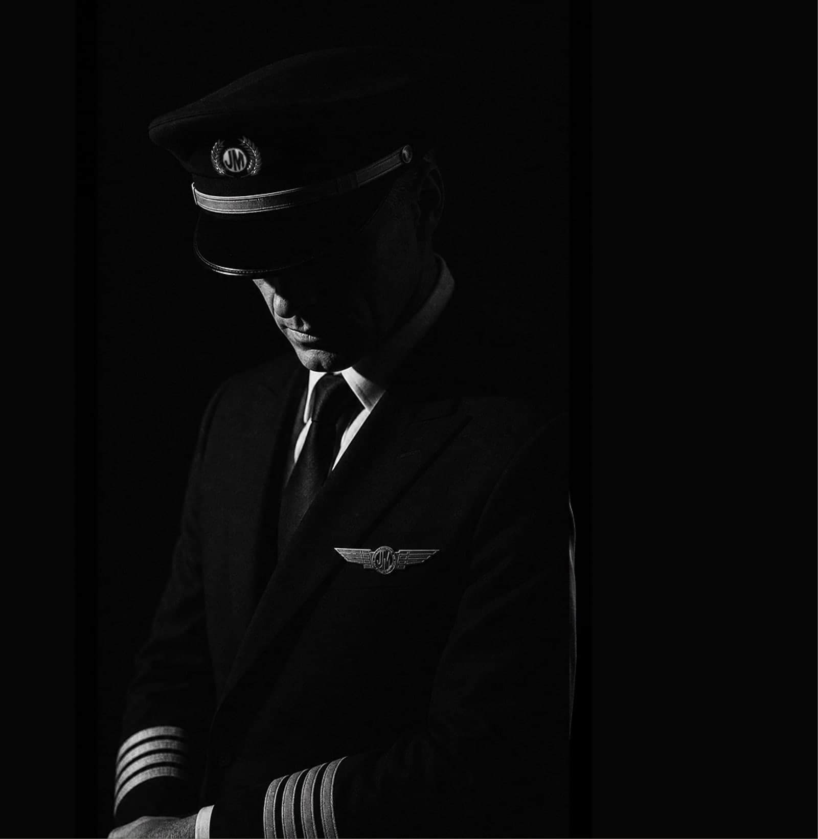 Jonny Masters in uniform, cap low, winged JM crest on the lapel